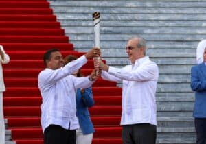 Banderas en ceremonia oficial en la escalinata con personas en trajes blancos y fondo de escaleras r.