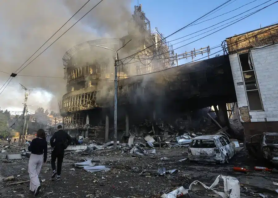 Varias personas caminan entre los escombros en el lugar donde un ataque ruso ha alcanzado un centro comercial en Kiev, Ucrania.
