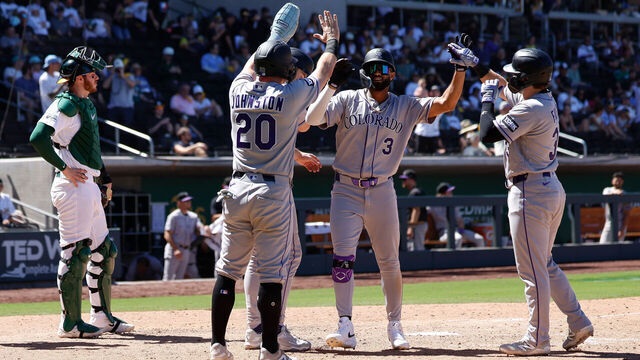 Willi Castro de los Rockies de Colorado, es saludado por sus compañeros luego de batear jonrón con las bases llenas.