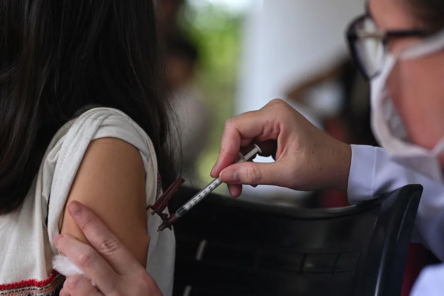 Una profesional de salud que aplica una dosis de la vacuna contra el dengue en Brasil.