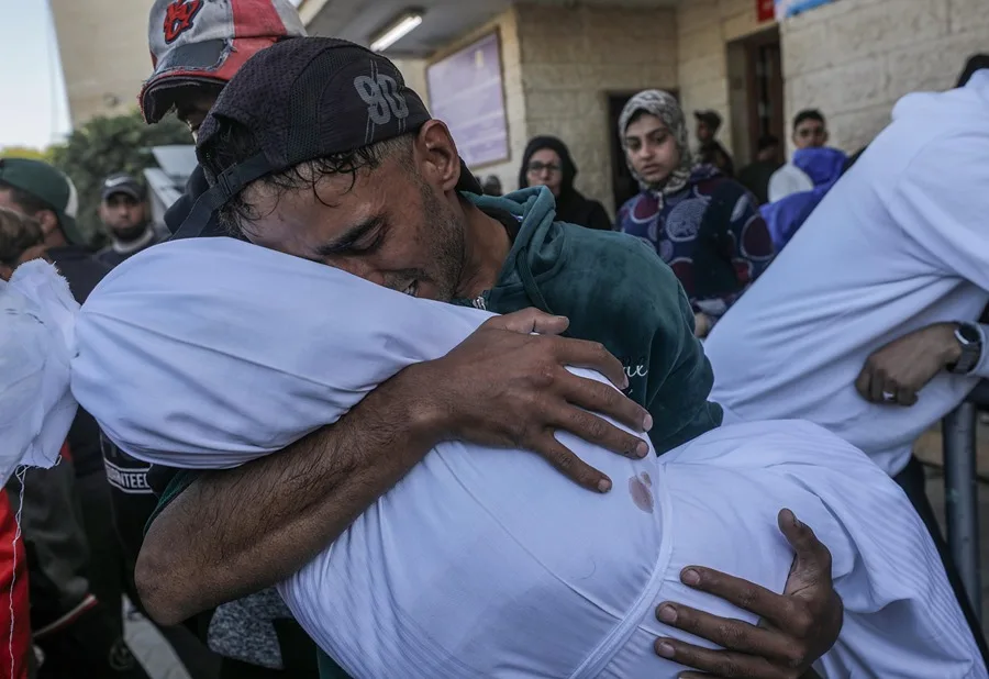 Un palestino lleva en brazos el cuerpo de su hija de 4 años, muerta en un ataque israelí, en una imagen de archivo. EFE/EPA/Mohammed Saber.