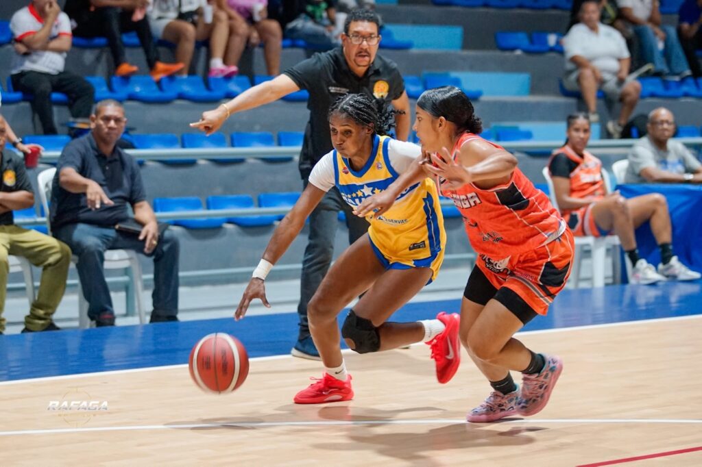 Gloribel Rodríguez, del club Mauricio Báez, es defendida por Katherine Abreu, La Ciénaga.