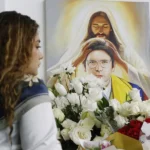 Una persona pone flores en un altar durante la conmemoración del primer aniversario del atentado contra Miguel Uribe Turbay en Bogotá (Colombia). EFE/ Mauricio Dueñas Castañeda.
