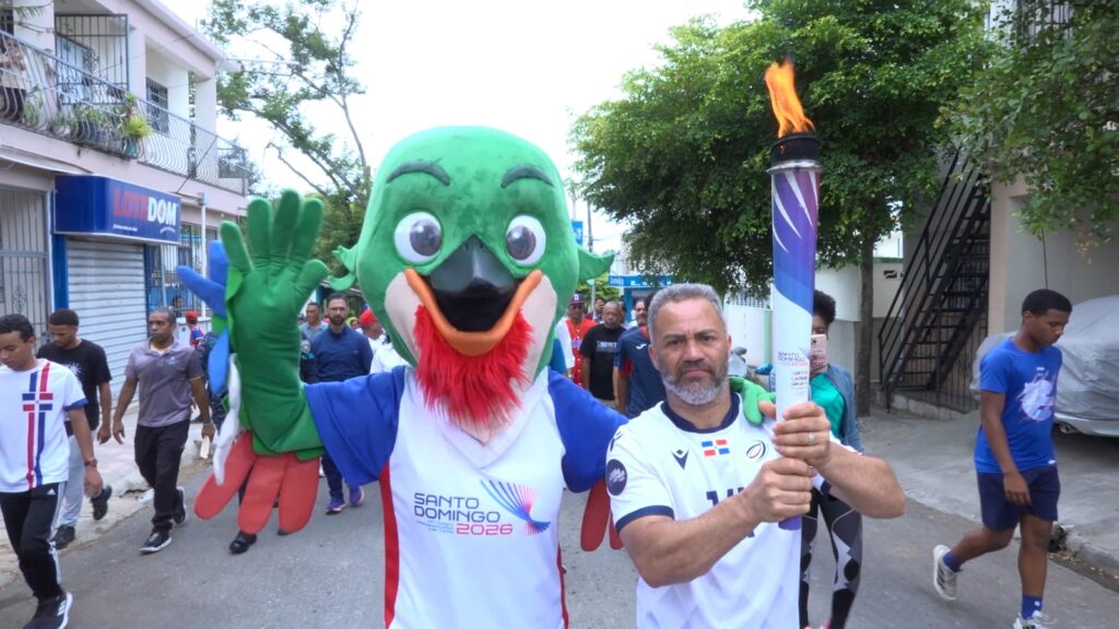 Alexander Crisóstomo, presidente de la Unión Deportiva provincial, camina, antorcha en mano, durante el recorrido por la ciudad de Moca.