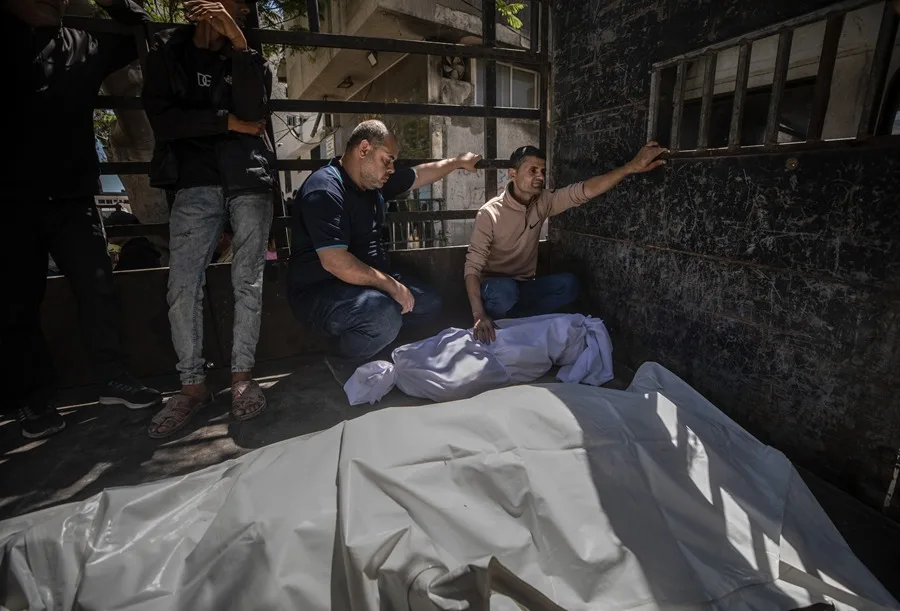 Familiares de una niña palestina y su madre se sientan junto a sus cuerpos en el Hospital Al Shifa de la ciudad de Gaza, el 28 de mayo de 2026.