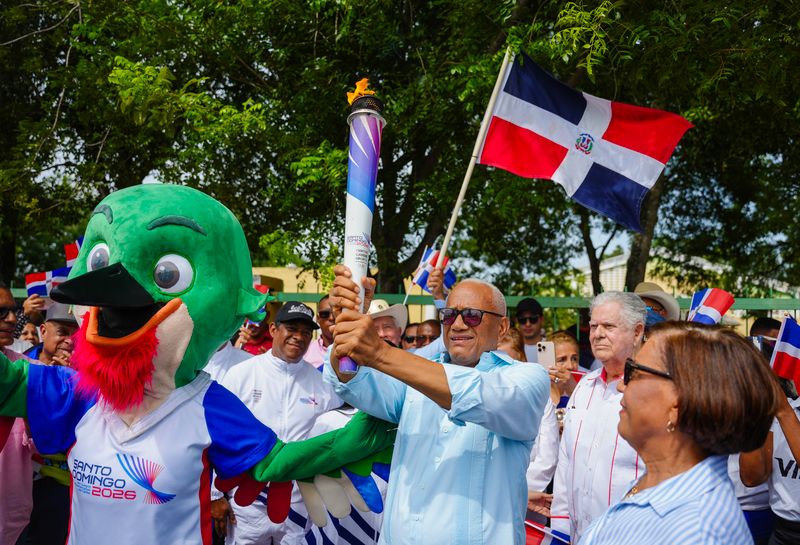 El exvelocista Porfirio –Popo- Veras Mercedes camina con la antorcha de los Juegos Centroamericanos y del Caribe Santo Domingo 2026 durante su recorrido por La Vega.