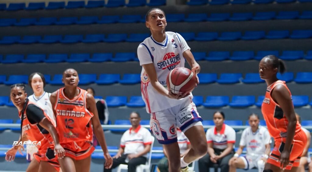 Vanessa Bautista, quien tuvo un auspicioso debut con San Lázaro, ejecuta una acción ofensiva ante la mirada de jugadora de La Ciénaga.