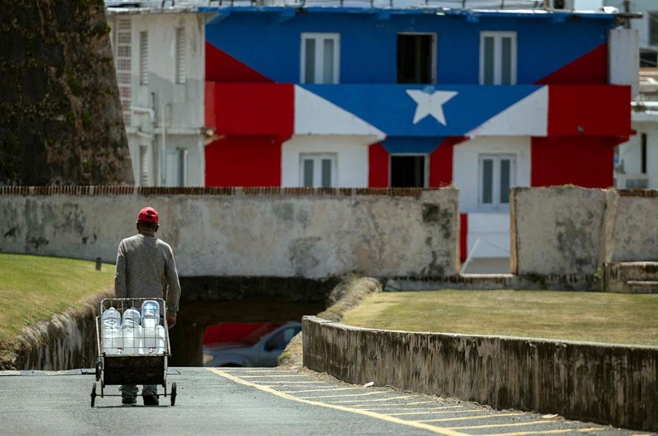 Hombre se abastece de agua en Puerto Rico