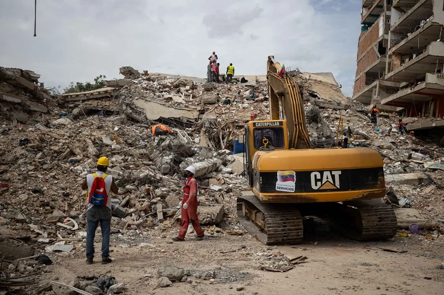 Integrantes de los cuerpos de rescate trabajan junto a maquinaria pesada para remover escombros en La Guaira (Venezuela). EFE/ Ronald Peña R.