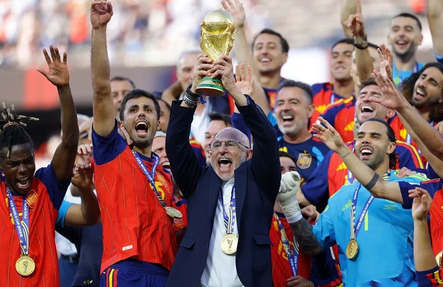 El seleccionador español, Luis de la Fuente, alza el trofeo de la Copa del Mundo mientras el equipo celebra la victoria en la final de la Copa del Mundo de la FIFA 2026 entre España y Argentina. EFE/EPA/CHRISTOPHER NEUNDORF.