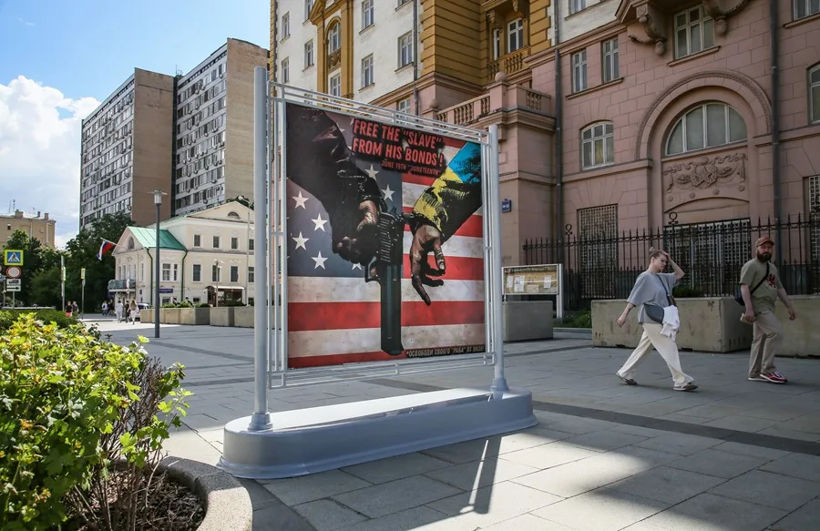Cartel en una calle de Moscú en el que aparece la mano de una persona con un traje con los colores de la bandera ucraniana (d) esposada a otra persona, frente a la embajada de Estados Unidos,en una imagen de archivo. EFE/EPA/Yuri Kochetkov.