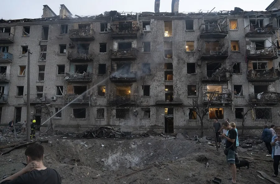 Residentes de un edificio de Kiev alcanzado por el ataque ruso del 2 de julio contemplan los daños causados. EFE/EPA/Tommaso Fumagallli.
