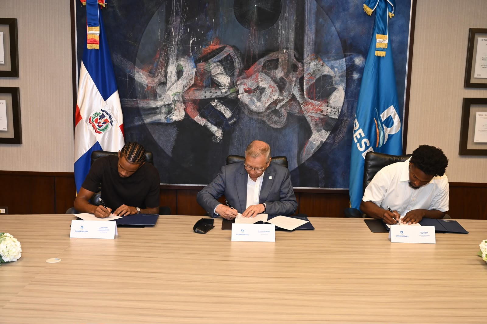 El presidente ejecutivo de Banreservas, doctor Leonardo Aguilera, firma un acuerdo de colaboración con los baloncestistas Jean Montero y Andrés Feliz, quienes desde ya son embajadores de la marca ante el mundo.