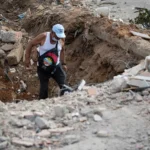 Un voluntario camina este domingo entre escombros de un edificio derrumbado por el doble terremoto, en La Guaira (Venezuela). EFE/ Ronald Peña R.