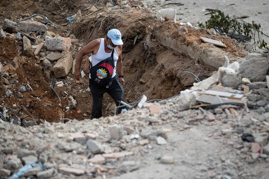 Un voluntario camina este domingo entre escombros de un edificio derrumbado por el doble terremoto, en La Guaira (Venezuela). EFE/ Ronald Peña R.