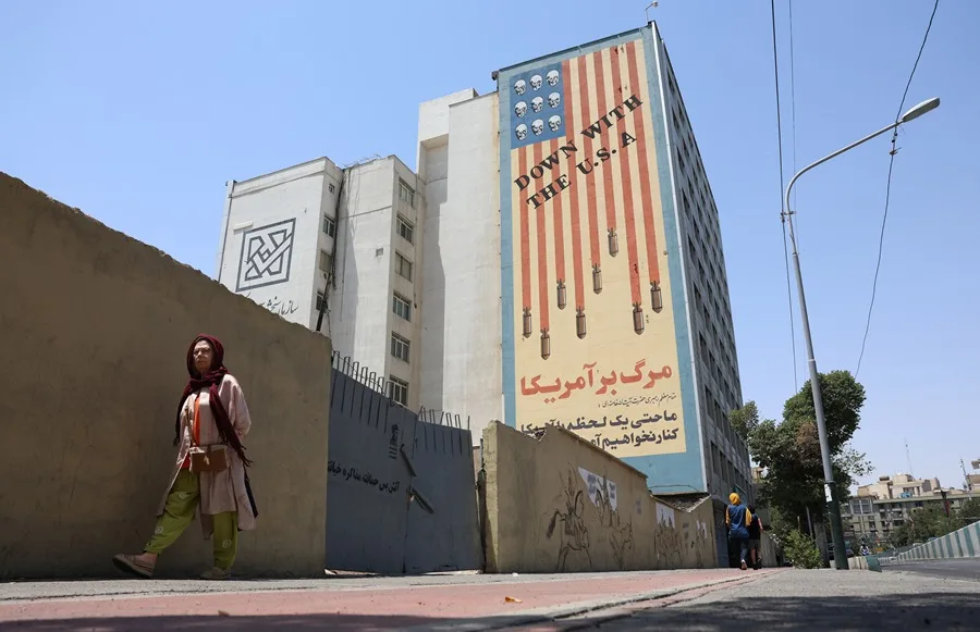 Una mujer iraní camina cerca de un mural antiamericano en una calle de Teherán, Irán, el 9 de julio de 2026 en Teherán (Irán).
