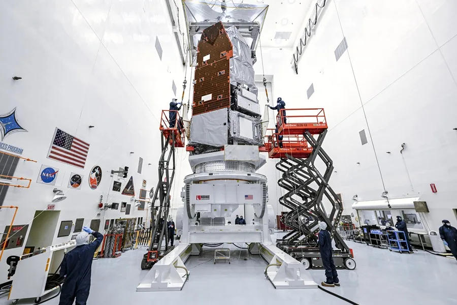 La NASA que muestra a técnicos e ingenieros utilizando una grúa para elevar el telescopio espacial Nancy Grace Roman hasta una plataforma especializada en el Centro Espacial Kennedy de la NASA, en Florida (EE.UU.)