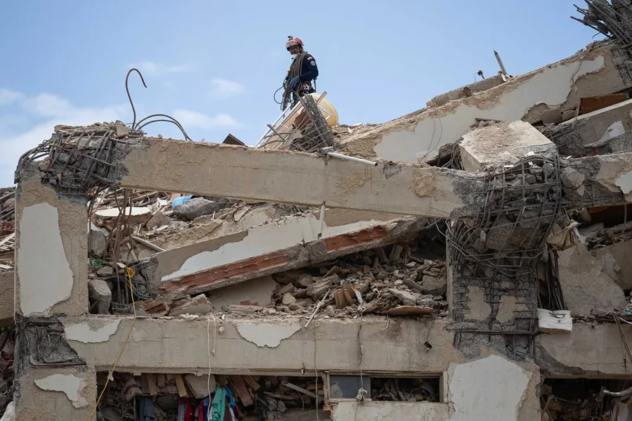 Una persona realizando labores de búsqueda entre los escombros de edificios destruidos por terremotos el 6 de julio de 2026, en La Guaira (Venezuela)